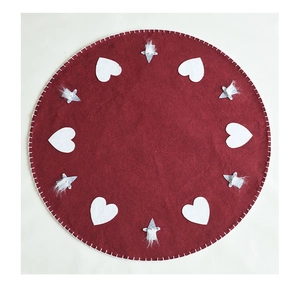 Detail of red wool felt Christmas tree skirt with white hearts and plush gnome figures