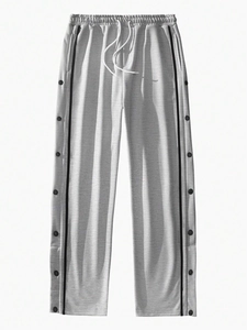 Detail of light gray joggers featuring side black stripes and full button snap closure