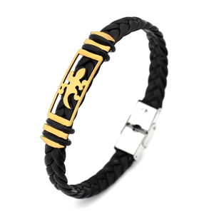 Detail view of black woven leather bracelet with golden gecko charm and silver clasp