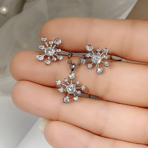Makroansicht von silbernem Schneeflocken Schmuckset mit klaren Kristallen in der Hand