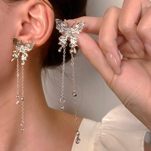 Detailed view of silver butterfly tassel earrings with long delicate hanging chains
