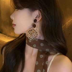 Elegant leopard print resin drop earrings on model with retro brown polka dot scarf