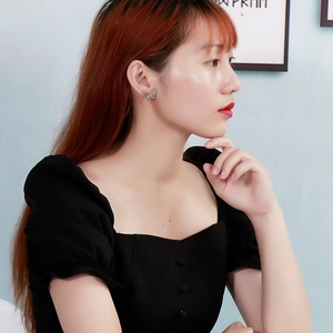 Gros plan d'une boucle d'oreille papillon argentée portée par un mannequin pour le style