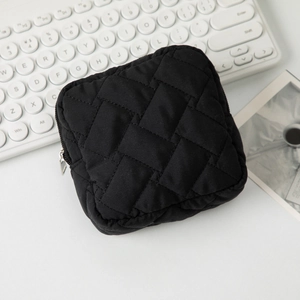 Détail macro d'une trousse de maquillage matelassée noire avec fermeture éclair argentée