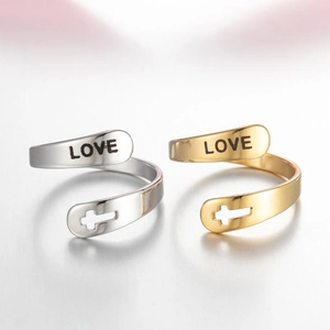 Detail of gold and silver stainless steel rings with LOVE text and cross cutouts