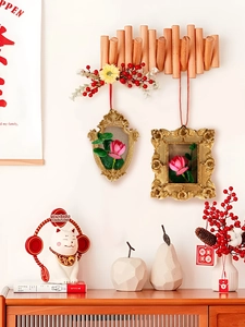 Detail of vintage gold embossed hanging frames with 3D floral accents on wooden rack