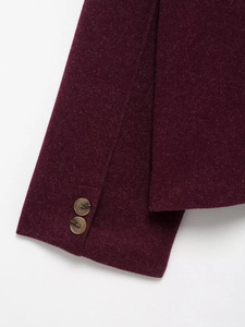 Close-up of wool texture and button detail on vintage loose long sleeve coat sleeve