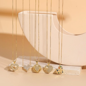 Close-up of assorted gold heart pendants with zircon stones on stone display stand