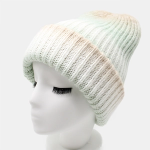 Detailed view of the ribbed knit texture and soft green-beige gradient on the winter hat