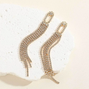 Macro detail of long golden tassel earrings with four rows of sparkling rhinestones