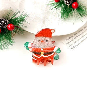 Detail of Santa Claus hair claw clip with red sequins and festive holiday decorations