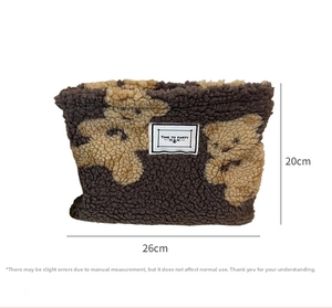 Detail shot of grey plush fleece makeup bag with brown teddy bear pattern and zipper