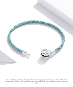 Close-up of sky blue braided leather bracelet with silver clover clasp for DIY jewelry