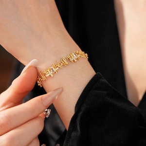 Gros plan d'un bracelet en or avec pendentif carré en zircon sur le poignet