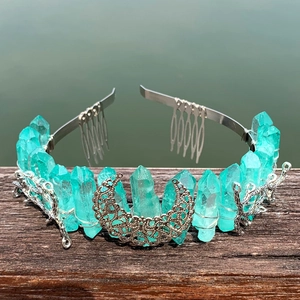 Detail of turquoise crystal crown with silver moon and branch accents on a metal headband