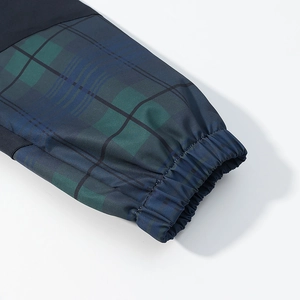 Détail de la veste à capuche à carreaux avec motif écossais bleu-vert et poignets élastiques
