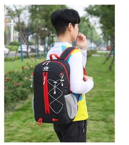Outdoor hiking backpack with red accents and elastic mesh pocket on a green lawn