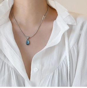 Macro shot of French vintage water drop pendant necklace with blue gemstone on snake chain