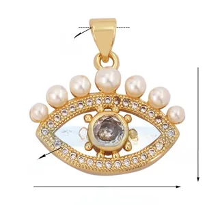 Detailed view of evil eye charm with sparkling zircons and white pearls in gold finish