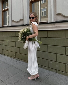 Détail de la robe en tricot crochet blanc avec col en V à volants et dentelle délicate