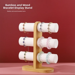 Three-tier bamboo bracelet holder with six white faux leather cylindrical display bars