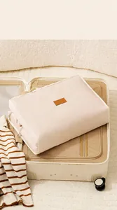 Custodia da viaggio beige con manico in una valigia aperta per l'organizzazione