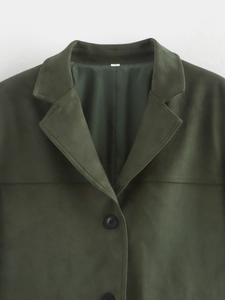 Detail of dark green faux suede blazer showing lapel collar and soft fabric texture