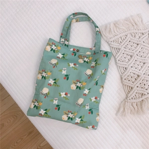Gros plan détaillé d'un sac en toile vert menthe à motif floral avec fermeture à pression