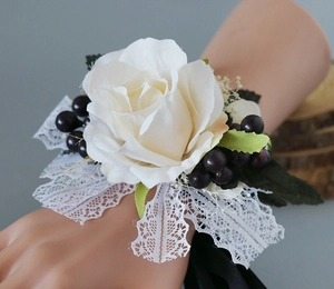 Gros plan d'un bracelet de fleurs de mariage en rose blanche et dentelle