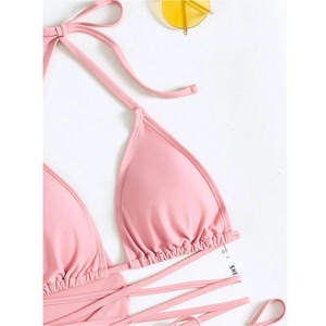 Detail of pink halter bikini top with ruched cups and size S label on white background