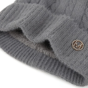 Détail de ce bonnet en maille gris foncé avec doublure polaire et logo M en strass