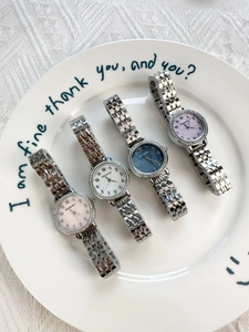 Close-up of four rhinestone quartz watches with stainless steel bands in assorted colors