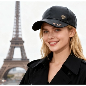 Close-up of black PU leather baseball cap with gold shield emblem and NY&JA embroidery