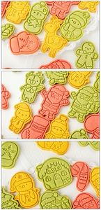 Flat lay of colorful Christmas cookies in Santa, reindeer, and snowman shapes on a white plate