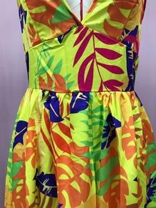 Detailed view of yellow tropical leaf print maxi dress with pleated high waist design