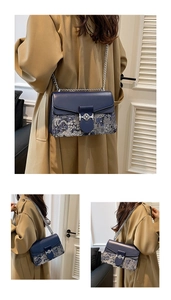 Elegant blue chain shoulder bag with unique mountain pattern worn with a trench coat