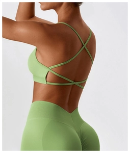 Detail of cross-back straps on grass green sports bra and V-shape high waist leggings