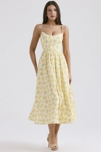 Close-up of yellow floral sundress with delicate spaghetti straps and summer pattern