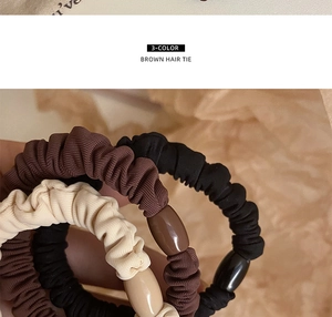 Detailed macro view of 3-color knit hair ties with beads in brown, black, and beige