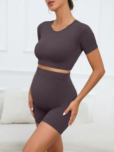 Detail of high-waist seamless maternity yoga shorts and short sleeve top in ribbed fabric