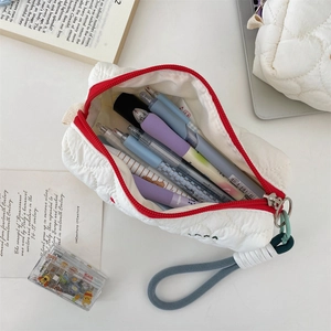 Close-up of white quilted stationery pouch with red zipper and large storage capacity
