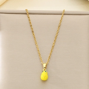 Close-up of yellow pear pendant necklace with green leaf detail and golden thin chain