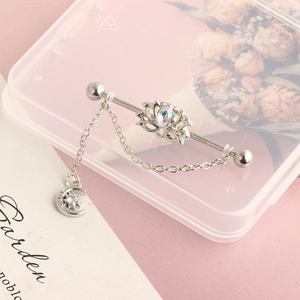 Detail of industrial barbell with lotus gemstone and moon star pendant chain