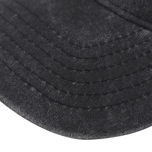 Detail of the reinforced stitching on the brim of a black washed cotton baseball cap