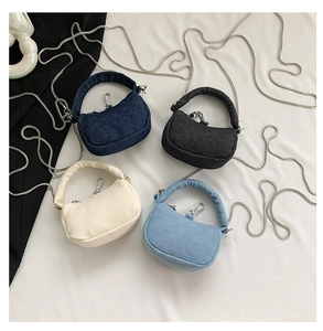 Detail shot of denim shoulder bags in navy, black, cream, and light blue with silver chains