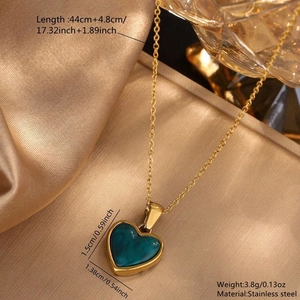 Detailed view of heart pendant necklace in gold stainless steel with peacock green finish
