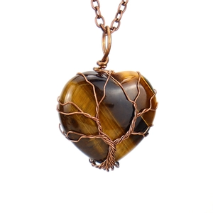 Detailed macro view of heart-shaped tiger eye stone with wire-wrapped tree of life design