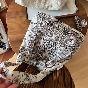 Détail de l'imprimé paisley sur sac cabas en lin avec bouton pression en métal