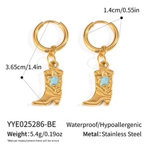 Détail des boucles d'oreilles bottes de cowboy en acier doré avec étoiles bleues