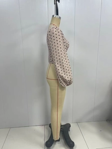 Vue latérale d'un haut court beige à pois avec manches bouffantes sur un mannequin